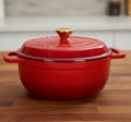 Red enameled cast iron cookware pot with lid on a butcher block counter