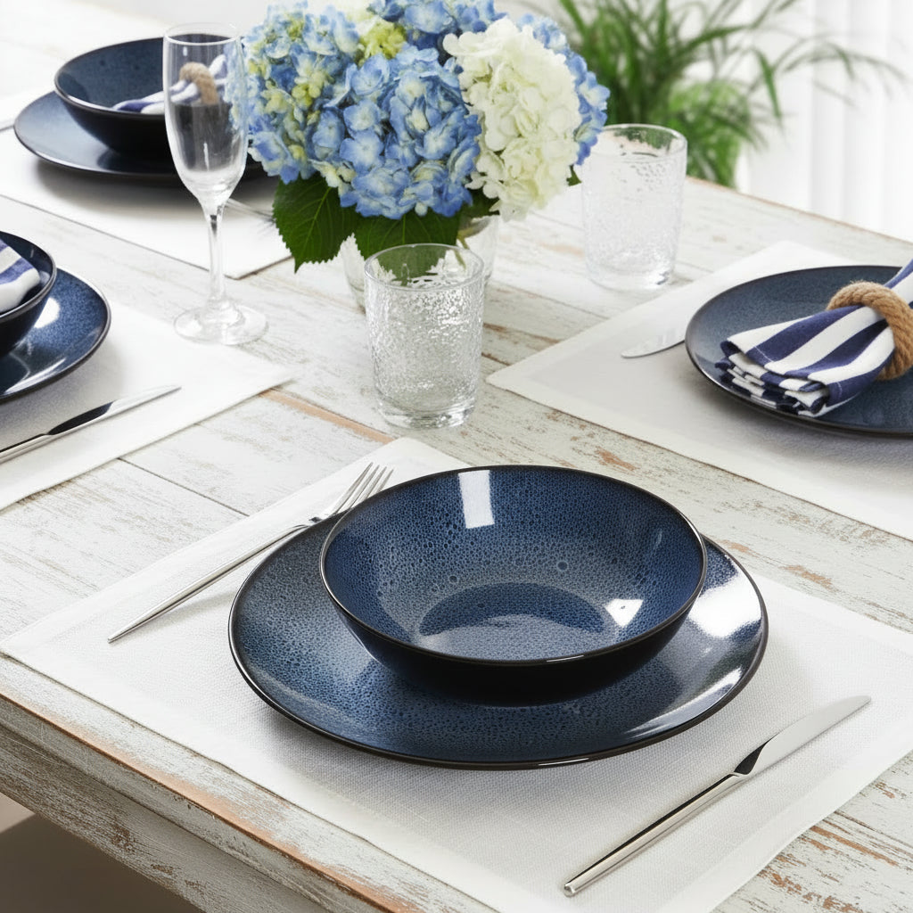 nantucket Blue ceramic dinnerware set on a white table with hydrangeas and cutlery.