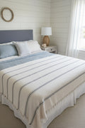 Bed with striped bedding in a bedroom setting