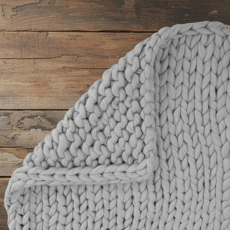 Close-up of a textured gray blanket on a white background