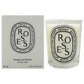 Diptyque Roses scented candle in a clear glass jar next to its light gray packaging box, both featuring the black and white circular 'ROSES' logo.