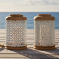 Two decorative lanterns with wooden tops and perforated metal bodies on a white background