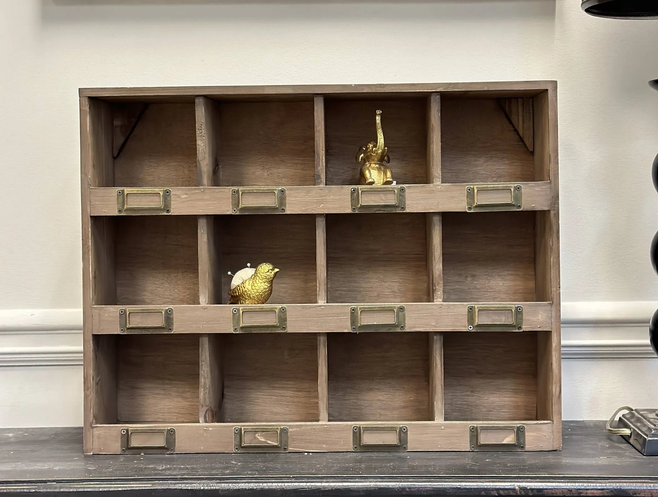 Wooden shelf with decorative items against a neutral wall